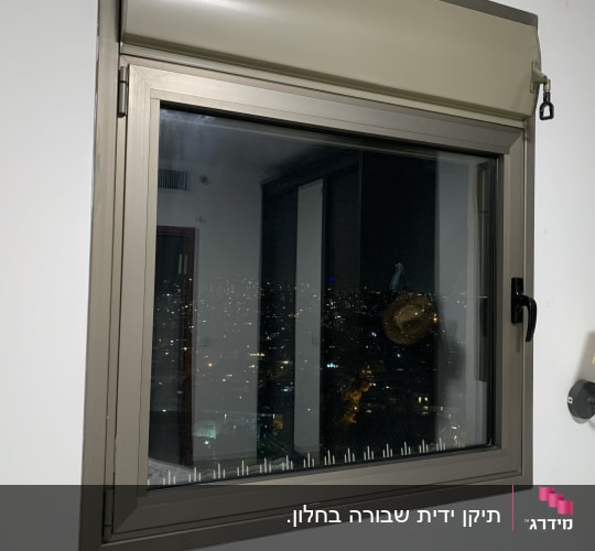 חלון עם תריס גלילה סגור חלקית